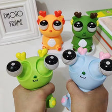 Colorful toy figures with large eyes held by hands against a white background.