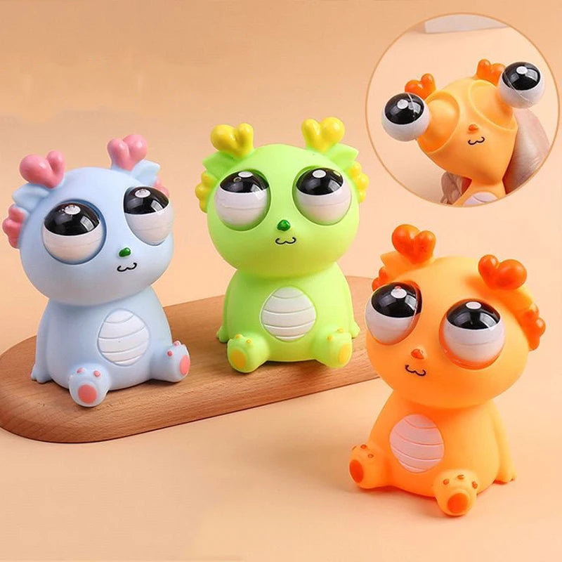 Three colorful cartoon-like animal figurines on a wooden surface with a beige background.