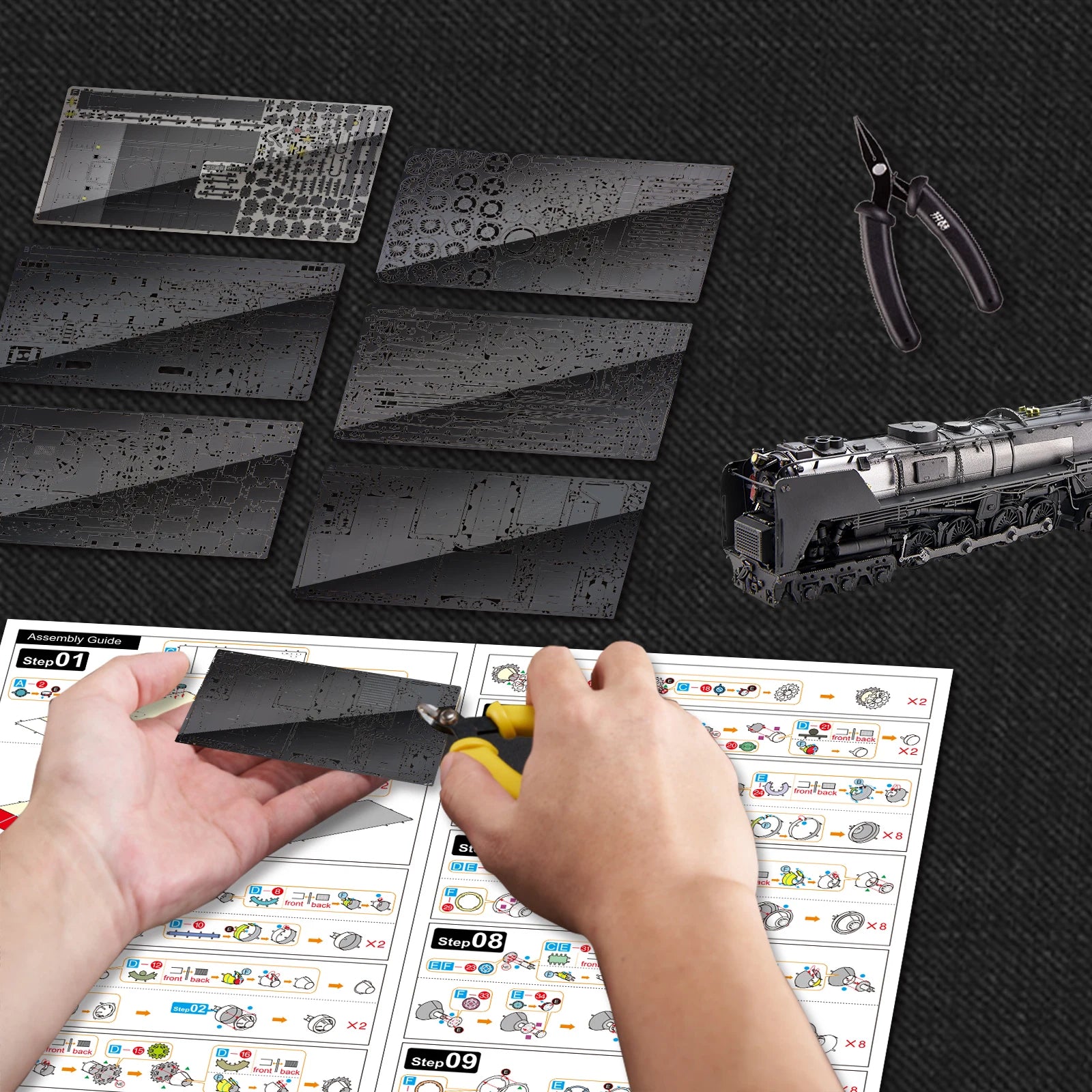 Model train building activity with cut-out parts and tools on a black textured surface.