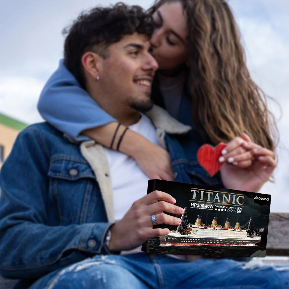 Two people holding a Titanic model kit with a scenic background