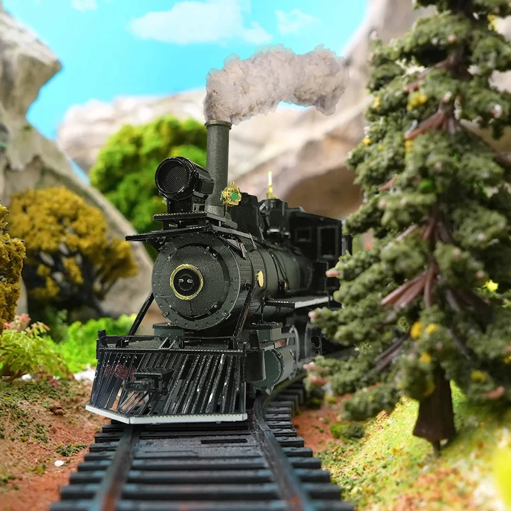 Model steam locomotive on tracks with a mountainous landscape in the background