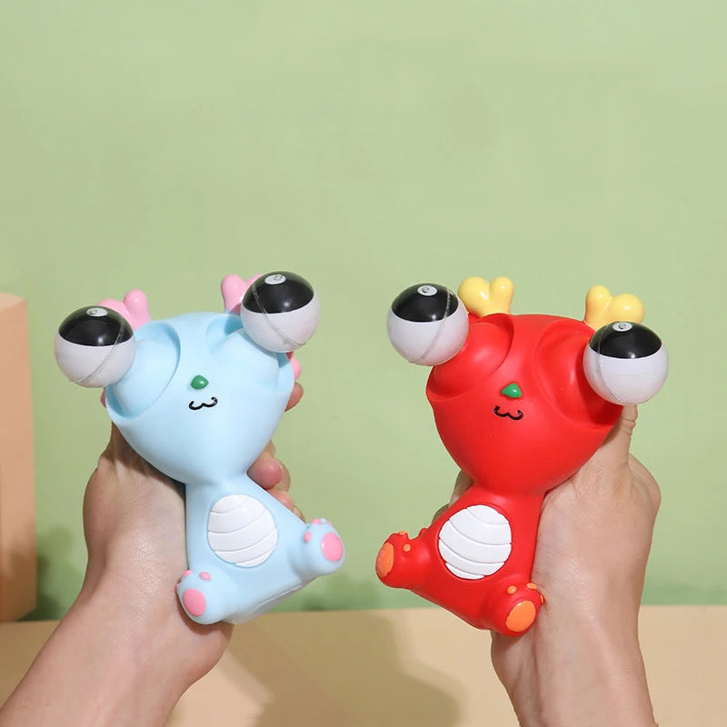 Two colorful plush toys, one blue and one red, held by hands against a green background.