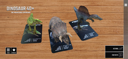 Dinosaur 4D+ Augmented Reality Cards Three dinosaur figurines on cards with 'Dinosaur 4D+' branding on a wooden surface.