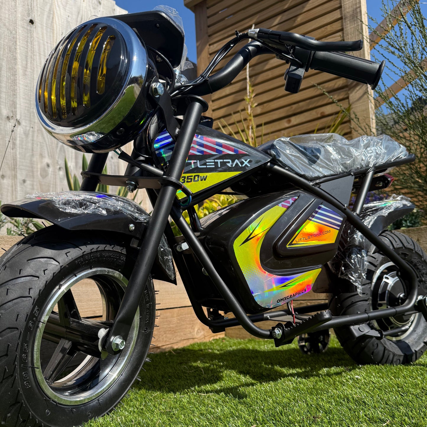 Littletrax 350W Kids Electric Bike Black electric bike with colorful design on grass