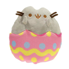 Plush toy resembling a cat in an Easter egg with pink and yellow pattern on a white background