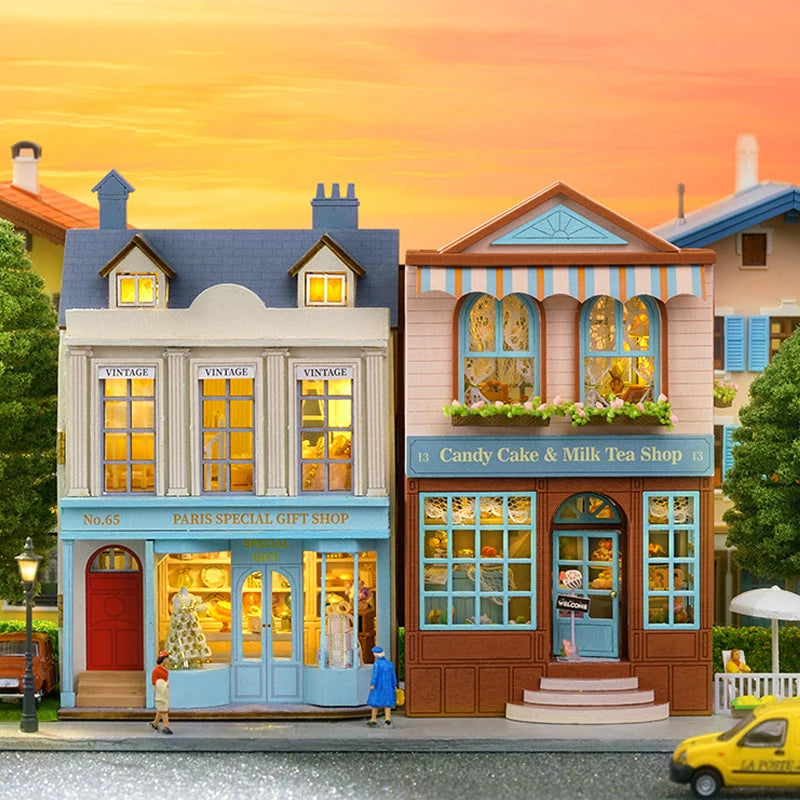 Illustration of a charming street with shops and people at sunset.