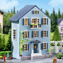 Model of a blue house with decorative elements in a garden setting