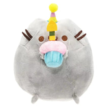 Plush toy resembling a cat with a birthday hat and cake on a white background