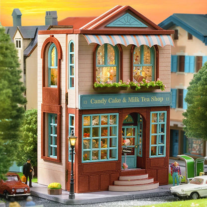 Toy model of a candy cake & milk tea shop with a colorful facade and small cars around.
