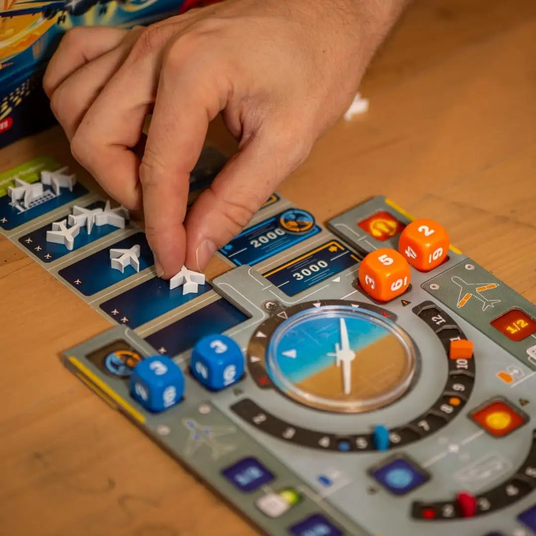 Hand playing Sky Team board game with dice and game pieces on a wooden table