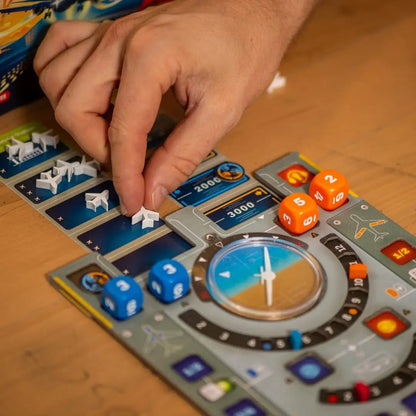Hand playing Sky Team board game with dice and game pieces on a wooden table