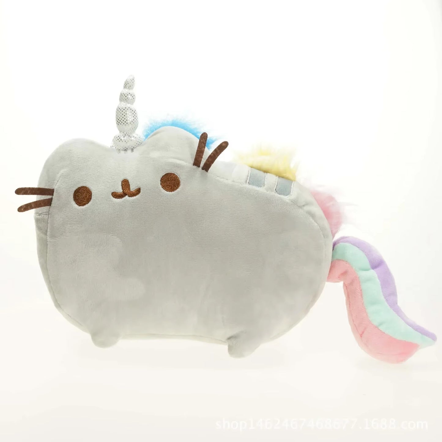 Plush toy resembling a cat with unicorn horns and rainbow tail on a white background