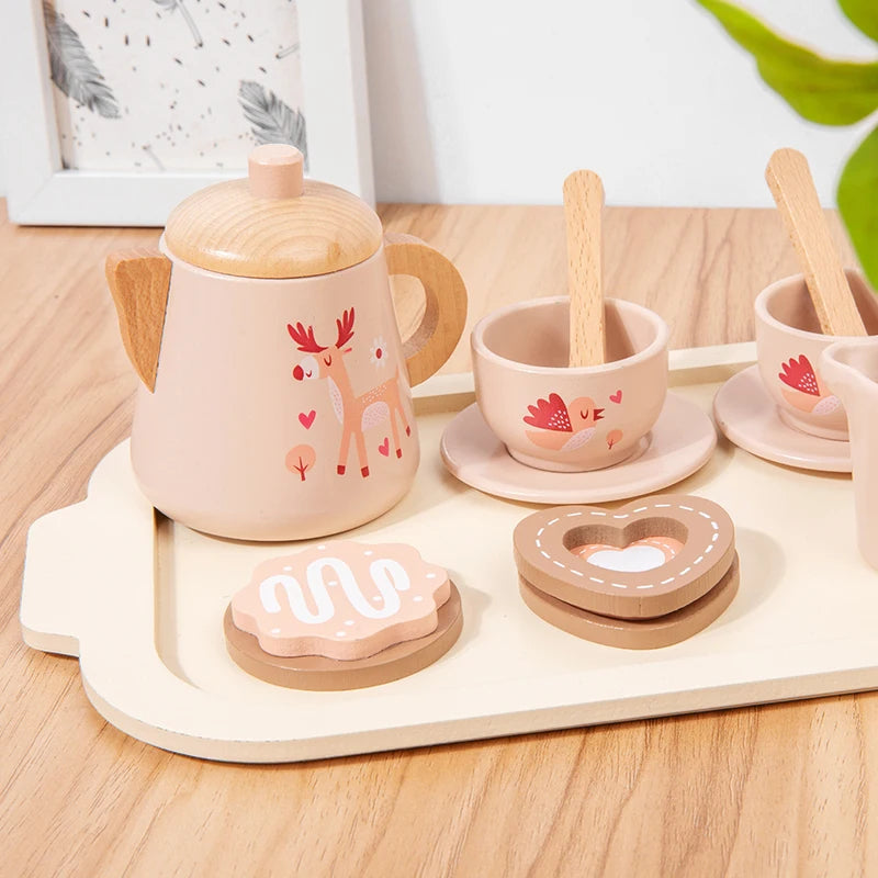Wooden toy tea set with pink teapot, cups, and cookies on a wooden tray.