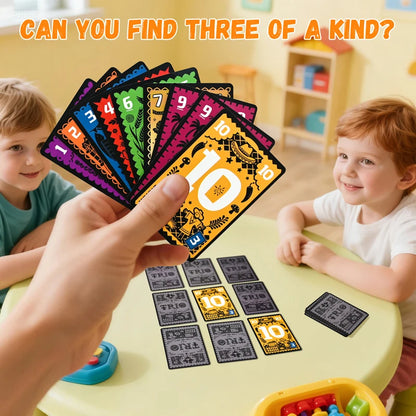 Children playing a card game with colorful cards and numbers, in a classroom setting.
