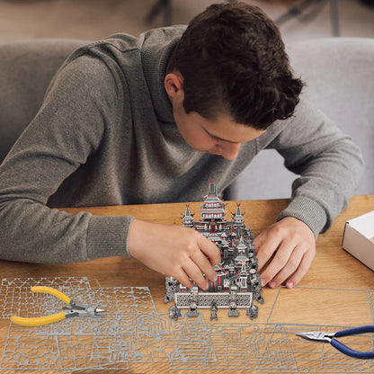 Person assembling a detailed model kit on a wooden table.