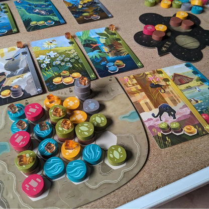 Board game with colorful tiles and pieces on a cork board surface