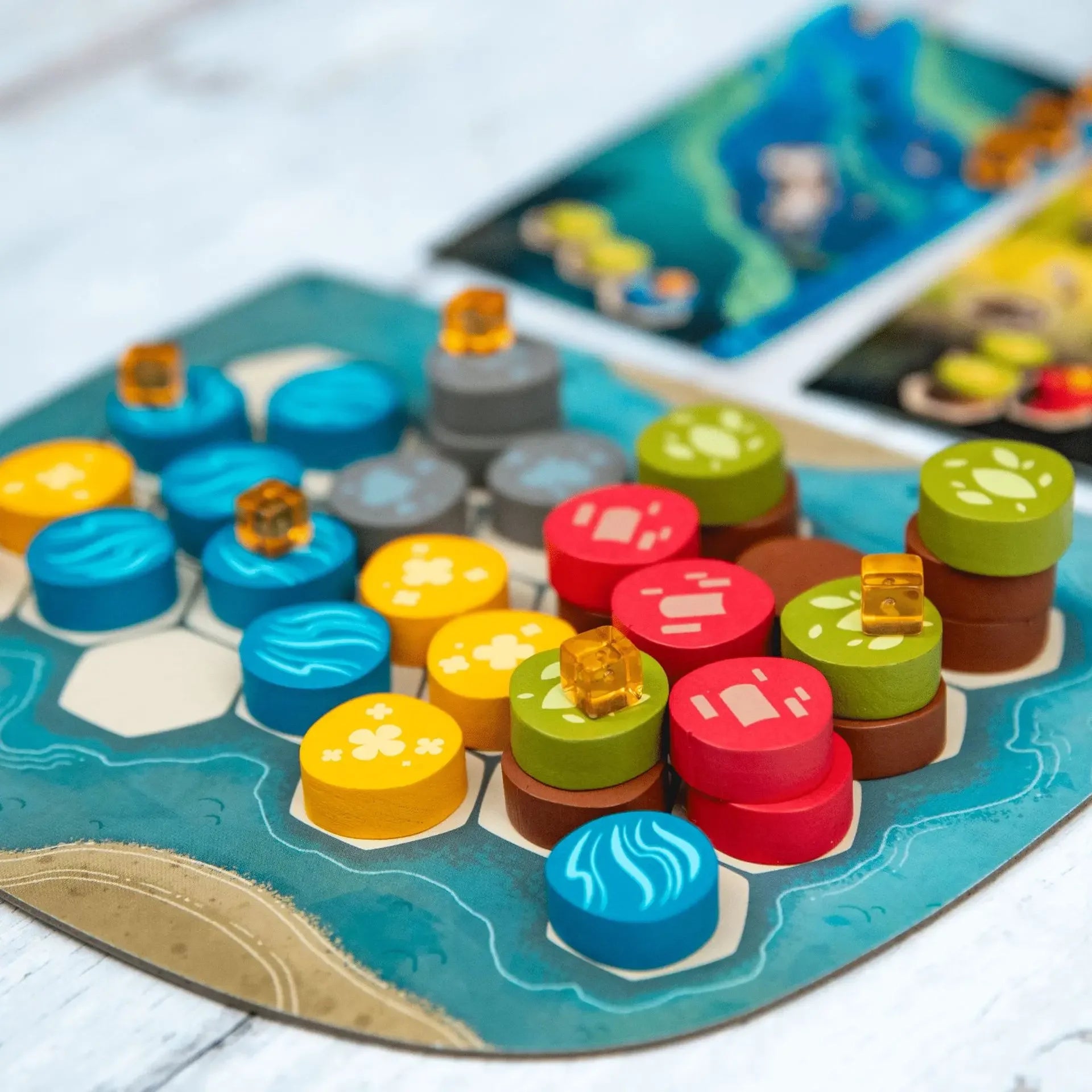 Colorful game pieces on a board game with cards in the background